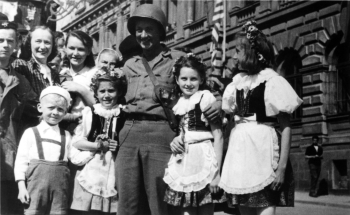 Desátník James M. Hughes, řidič amerického džípu z velitelství 22. polního dělostřelectva 4. obrněné divize, který dorazil 9. 5. 1945 do Příbrami, se zdejšími dětmi. V popředí zleva Havel a Mandová, za nimi Suchopár a Chocholová.